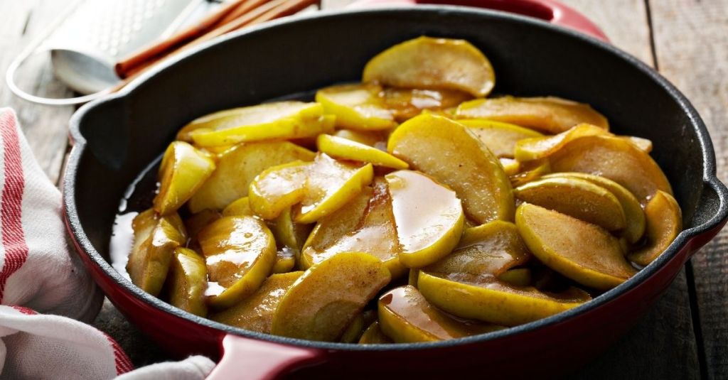 Cast iron skillet filled with caramelized apple slices, showcasing its even heating properties.