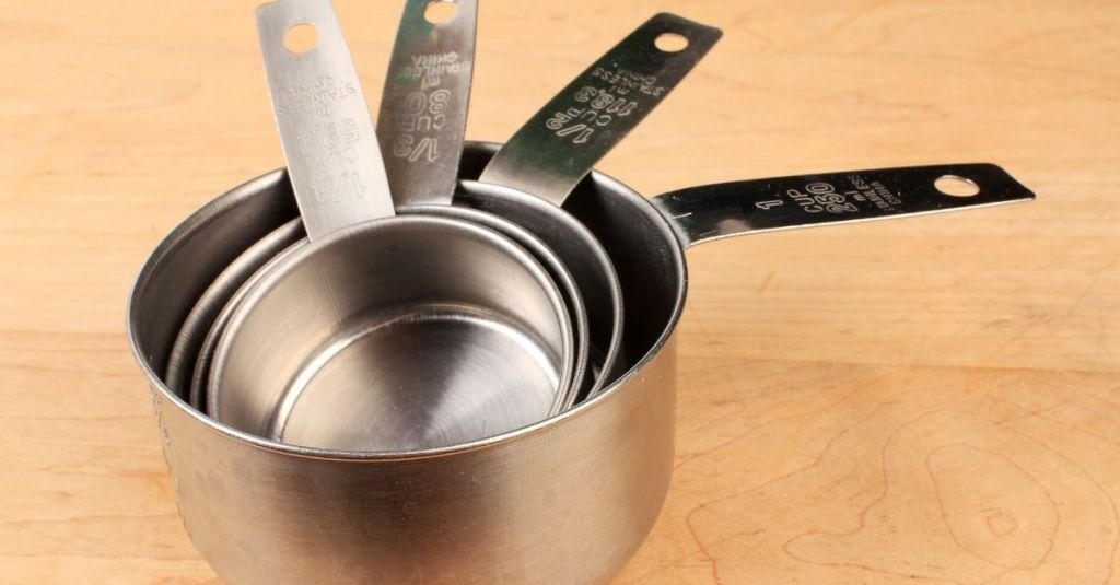 Set of stainless steel measuring cups, essential for exact ingredient portions in baking and cooking.