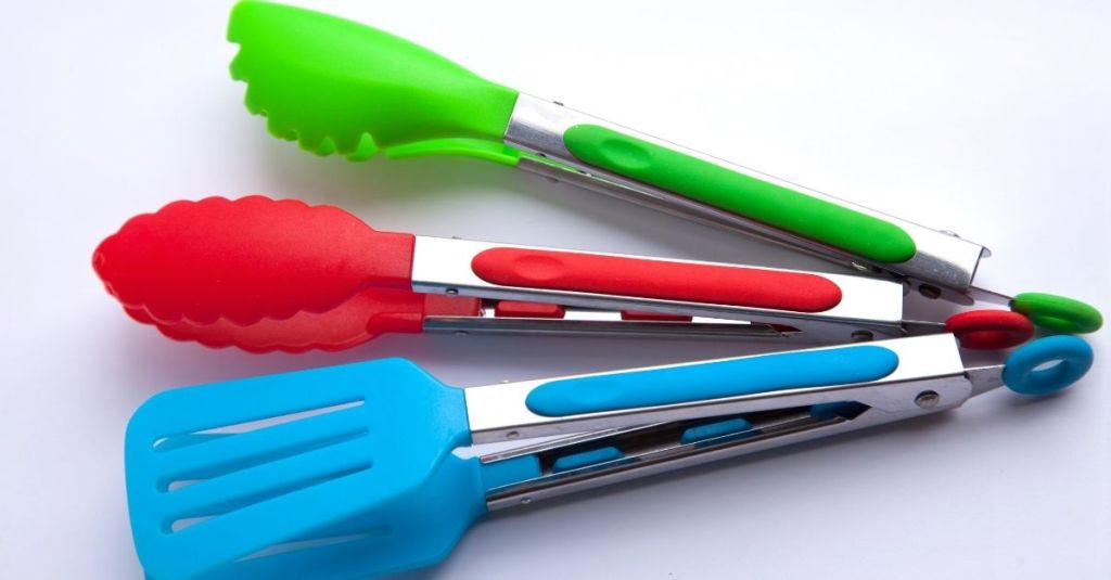 Colorful silicone-tipped tongs in green, red, and blue, essential for safe food handling.
