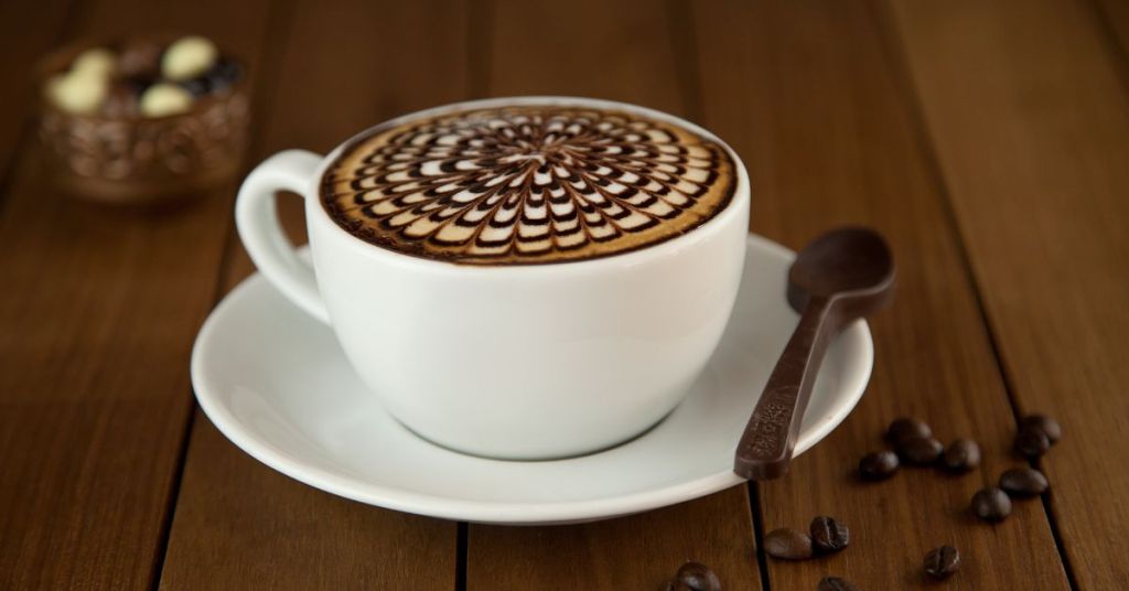 Cappuccino with intricate chocolate art on the froth.