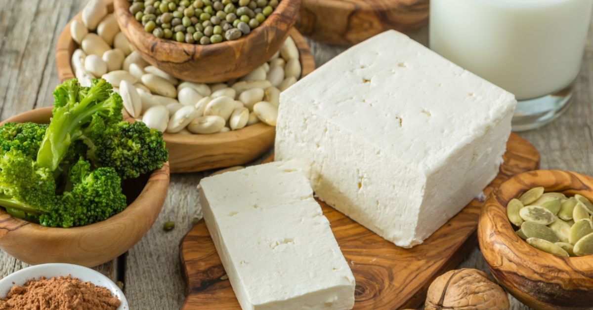 A variety of plant-based proteins rich in essential nutrients. An assortment of plant-based protein foods including tofu, legumes, nuts, and broccoli, illustrating diverse dietary choices.