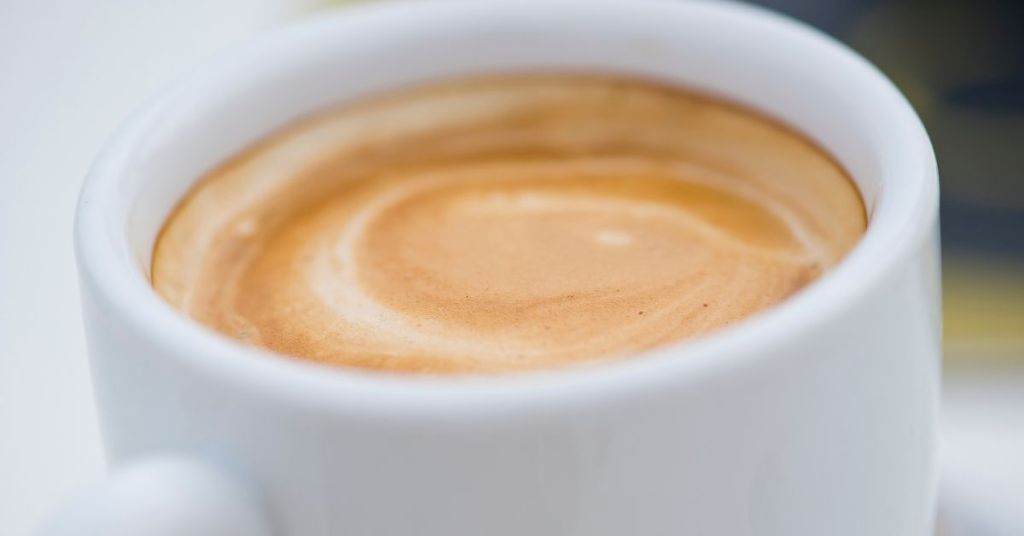 Espresso shot with rich crema in a white cup.