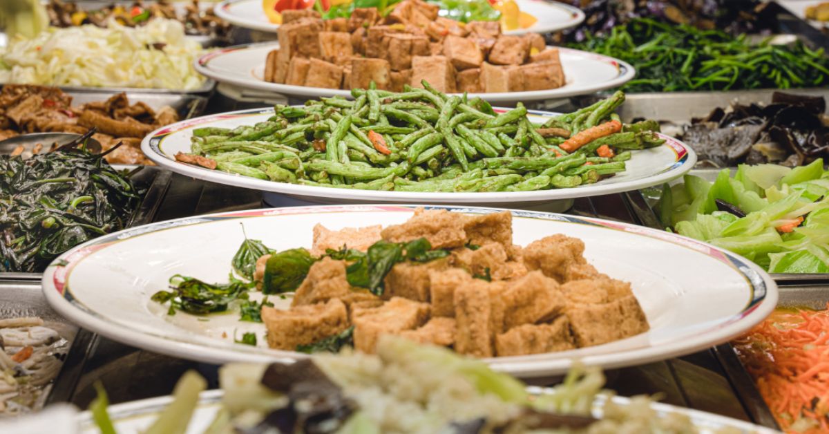 A diverse vegan buffet offers delicious and healthy plant-based meal choices. A spread of various plant-based dishes on buffet tables, showcasing colorful vegetables, tofu, and grains for a healthy meal.