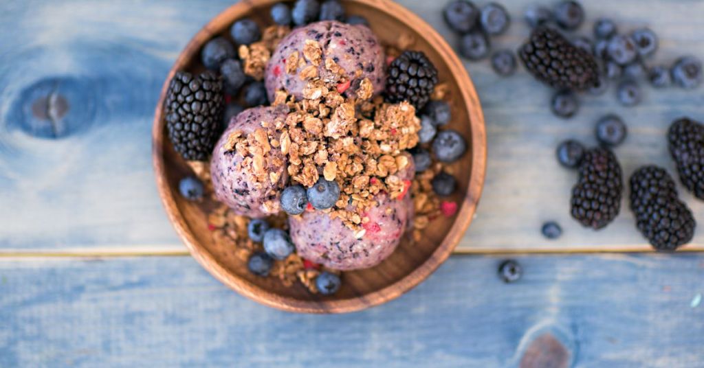 Blueberry sorbet served in a bowl, topped with granola, blackberries, and fresh blueberries. Dairy-free blueberry sorbet served in a bowl, topped with granola, blackberries, and blueberries.