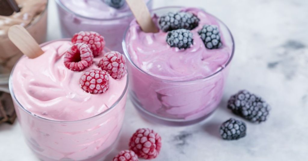 Whipped berry mousse served in glasses, garnished with raspberries and blackberries. Dairy-free berry yogurt mousse topped with raspberries and blackberries.