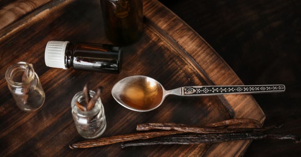 Tools and ingredients for making vanilla extract. Vanilla extract preparation tools including glass bottles, measuring spoons, and split vanilla beans.