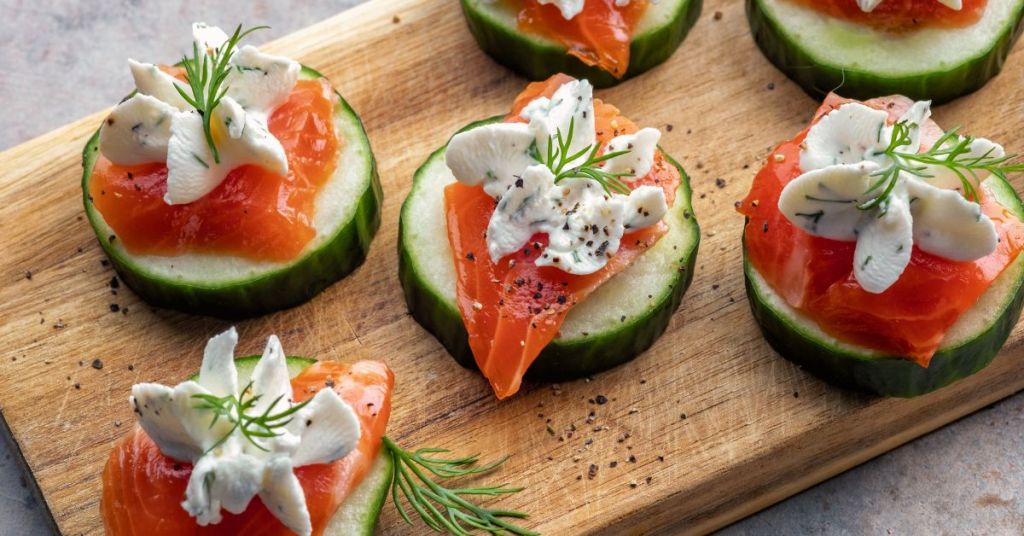Bite-sized smoked salmon on cucumber slices, topped with herbed cream and garnished with dill.